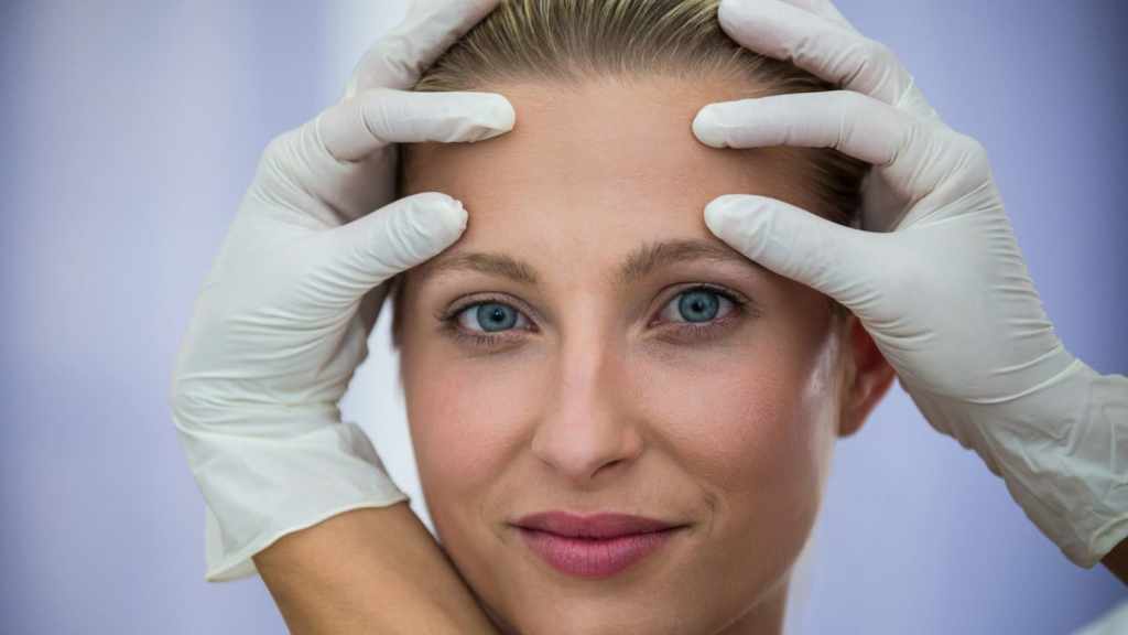 Woman receiving Botox evaluation on forehead, representing Botox before and after treatment expectations.