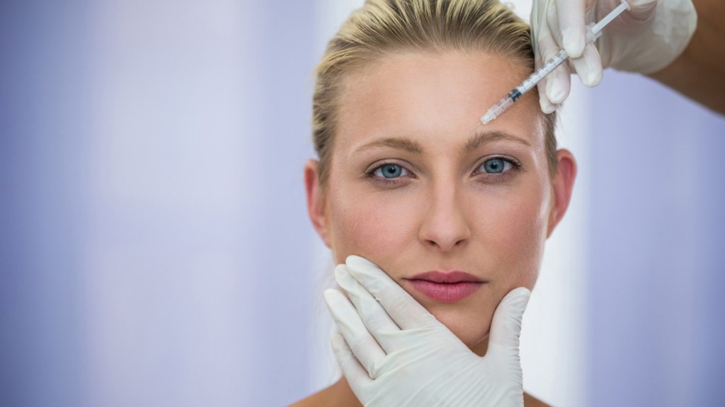 Woman receiving Botox injection in forehead area, illustrating typical treatment for how many units of Botox are used for forehead lines.