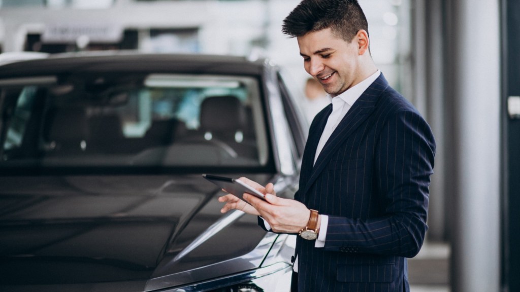 Man reviewing paperwork beside a new car, illustrating how to finance a car and compare auto loan options.
